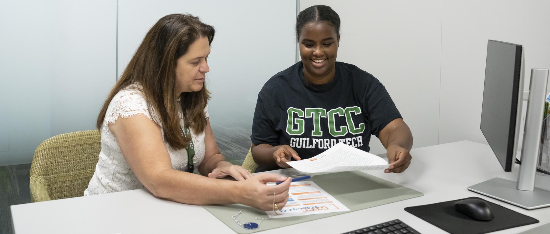 A female advisor talks to a female student.